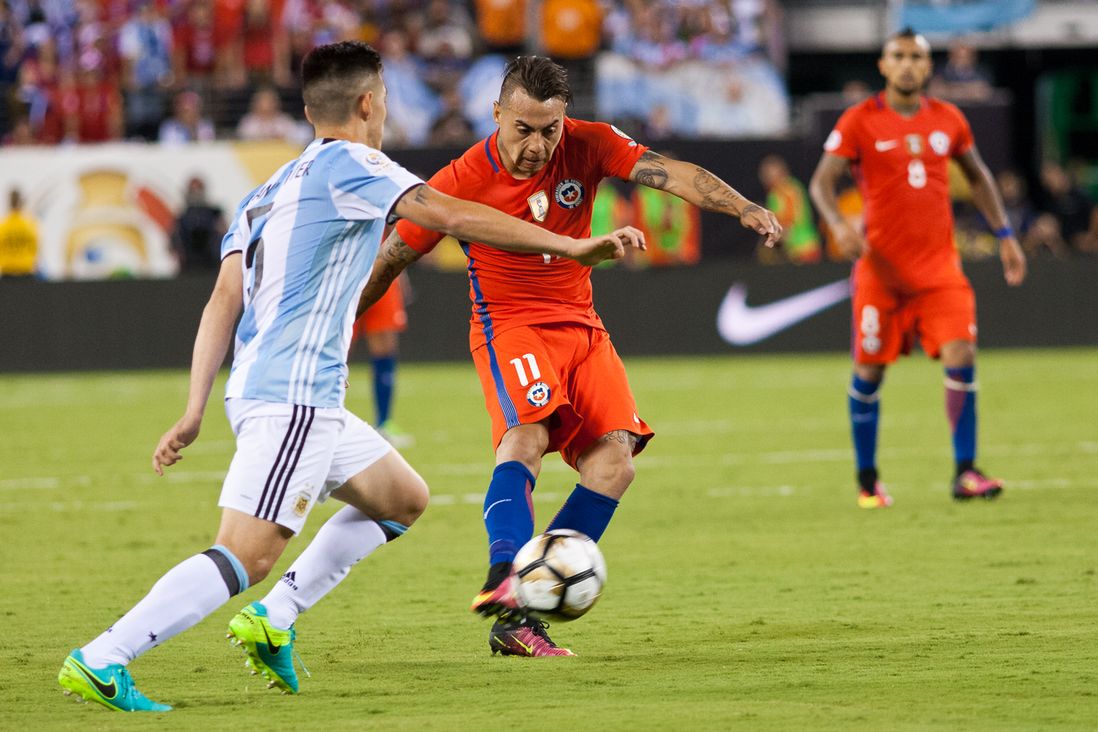 Chile's Eduardo Vargas (11) passes the ball while Argentina's Matias Kranevitter (left) defends.